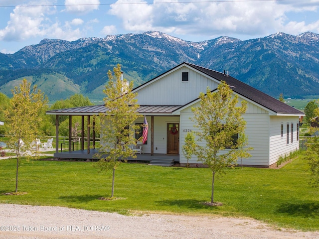 4326 State Line Rd, Freedom, WY 83120 - view of front of house with a mountain view, a porch, a standing seam roof, a front lawn, and a metal roof