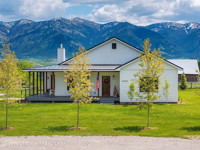 4326 State Line Rd, Freedom, WY 83120 - view of front of property featuring a chimney, covered porch, a mountain view, and a front yard
