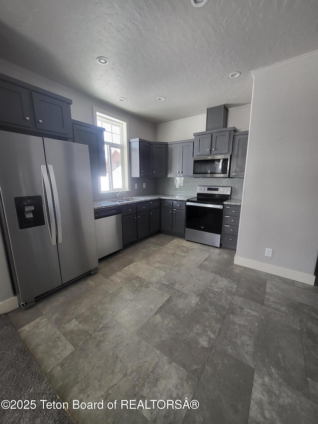 360 Wooden Spur Dr, Alpine, WY 83128 - kitchen with appliances with stainless steel finishes, a textured ceiling, light countertops, and gray cabinetry