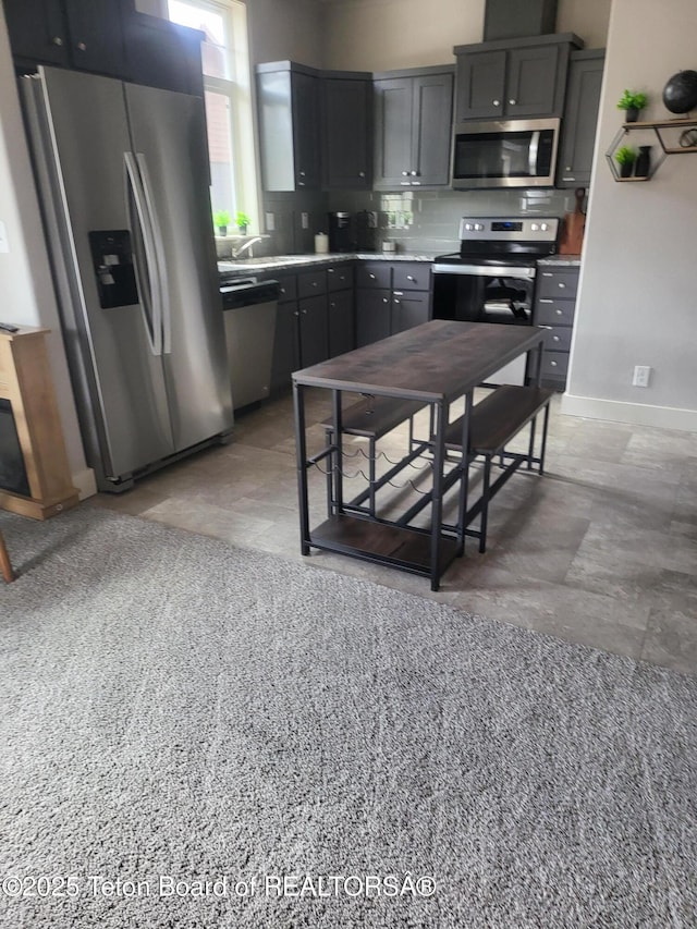 360 Wooden Spur Dr, Alpine, WY 83128 - kitchen featuring appliances with stainless steel finishes, light countertops, backsplash, and gray cabinetry