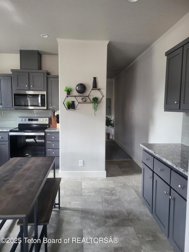 360 Wooden Spur Dr, Alpine, WY 83128 - kitchen with appliances with stainless steel finishes, decorative backsplash, ornamental molding, light stone counters, and gray cabinets