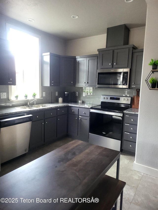 360 Wooden Spur Dr, Alpine, WY 83128 - kitchen featuring stainless steel appliances, decorative backsplash, gray cabinets, light stone countertops, and recessed lighting