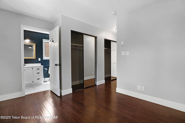 512 S Millward Unit 512, Jackson, WY 83001 - unfurnished bedroom featuring baseboards, multiple closets, wood finished floors, and ensuite bathroom