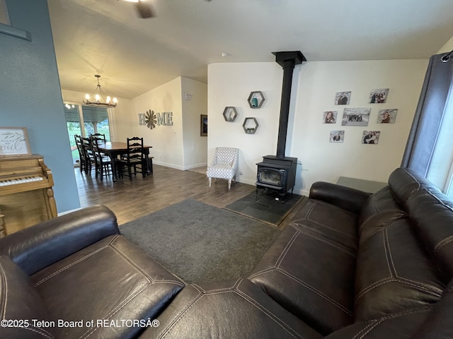 350 Worton Ln, Auburn, WY 83111 - living area featuring a chandelier, wood finished floors, vaulted ceiling, a wood stove, and baseboards