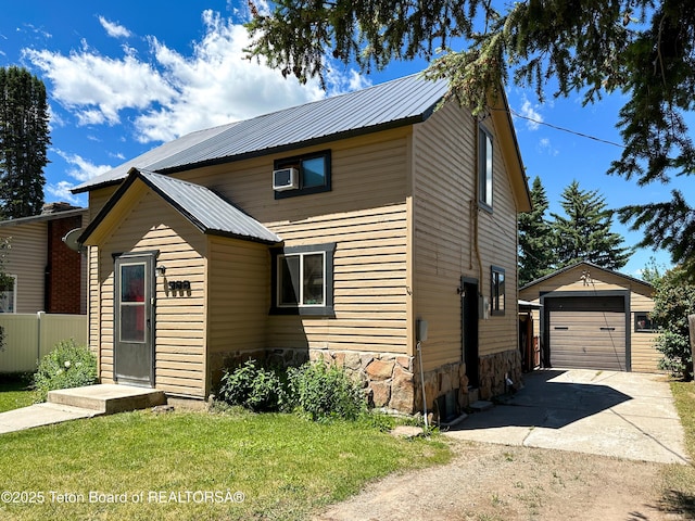 566 Jefferson St, Afton, WY 83110 - traditional home with concrete driveway, an outbuilding, a metal roof, and stone siding