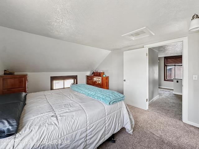 566 Jefferson St, Afton, WY 83110 - carpeted bedroom featuring attic access, a textured ceiling, and lofted ceiling