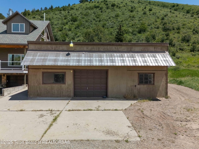 2840 E Dry Crk, Afton, WY 83110 - view of front facade with a metal roof, concrete driveway, a forest view, and a garage