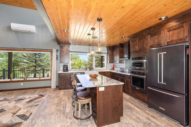 2840 E Dry Crk, Afton, WY 83110 - kitchen with high end fridge, wooden ceiling, wall chimney range hood, a wall mounted AC, and a kitchen island