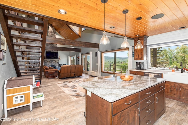 2840 E Dry Crk, Afton, WY 83110 - kitchen featuring wooden ceiling, decorative light fixtures, a stone fireplace, light wood-style flooring, and light stone counters