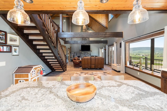 2840 E Dry Crk, Afton, WY 83110 - living area featuring stairway, high vaulted ceiling, wood finished floors, a fireplace, and beamed ceiling