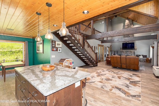 2840 E Dry Crk, Afton, WY 83110 - kitchen featuring decorative light fixtures, a kitchen island, light stone countertops, a kitchen bar, and high vaulted ceiling