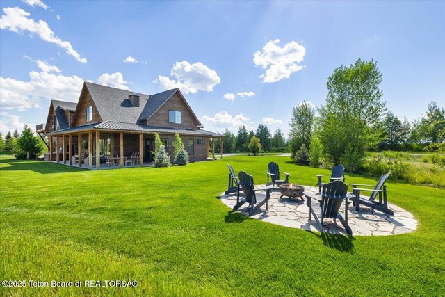 346 S Leigh Ranch Rd, Tetonia, ID 83452 - back of property featuring an outdoor fire pit, a patio, a yard, and a metal roof