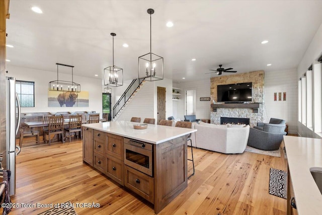 346 S Leigh Ranch Rd, Tetonia, ID 83452 - kitchen with stainless steel appliances, a kitchen breakfast bar, light wood-style flooring, a fireplace, and recessed lighting