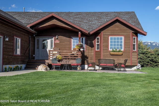 891 Paiute St, Driggs, ID 83422 - view of front of house featuring a front yard, an outdoor hangout area, roof with shingles, a patio, and entry steps