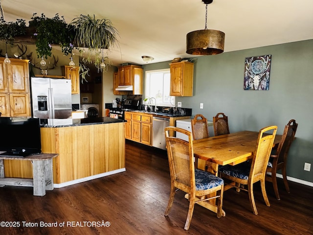 27 Chief Joseph, Daniel, WY 83115 - kitchen featuring appliances with stainless steel finishes, dark wood-style floors, dark countertops, and washer / dryer