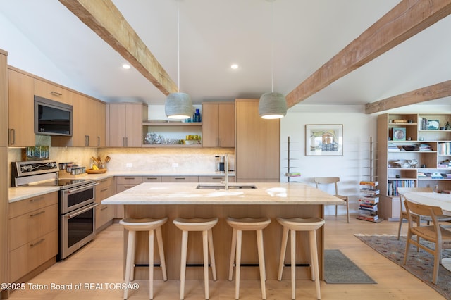 525 E Golf Creek Ln Unit 34, Jackson, WY 83001 - kitchen featuring appliances with stainless steel finishes, beam ceiling, light brown cabinets, a kitchen breakfast bar, and open shelves