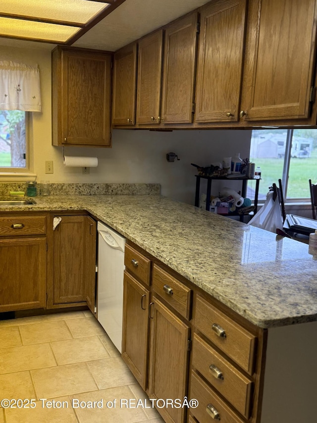 144 Blue Lake Cir, Alpine, WY 83128 - kitchen with dishwasher, healthy amount of natural light, a peninsula, and light tile patterned floors