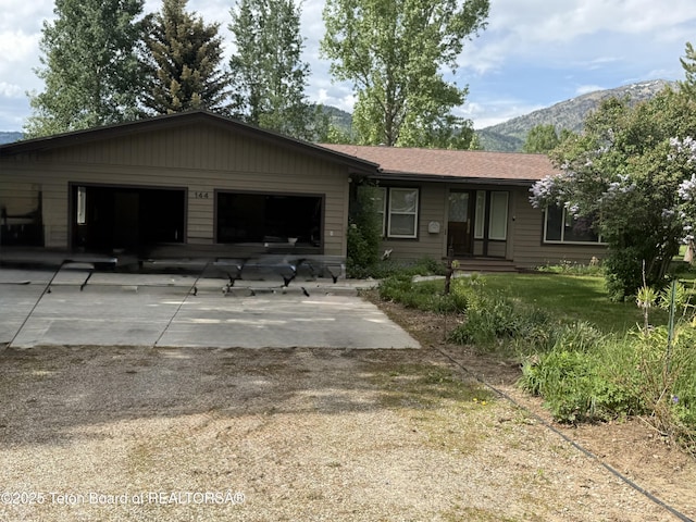 144 Blue Lake Cir, Alpine, WY 83128 - ranch-style house featuring a mountain view, concrete driveway, and an attached garage