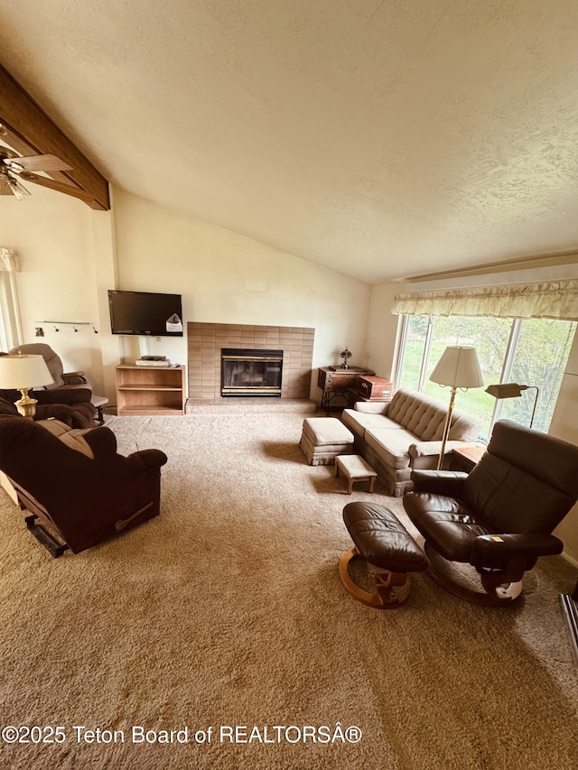 144 Blue Lake Cir, Alpine, WY 83128 - carpeted living room with lofted ceiling, a fireplace, a textured ceiling, and ceiling fan