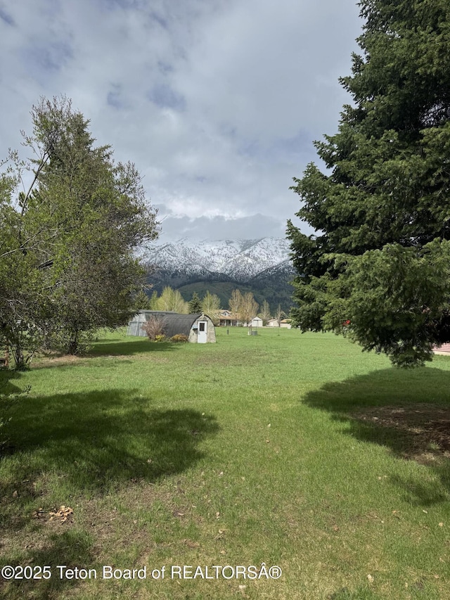 144 Blue Lake Cir, Alpine, WY 83128 - view of grassy yard with a shed and a mountain view