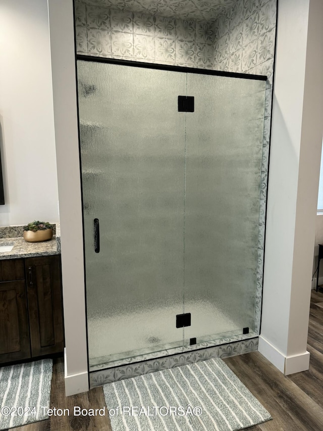 241 Cedar Creek Dr, Star Valley Ranch, WY 83127 - bathroom with wood finished floors, a stall shower, and vanity