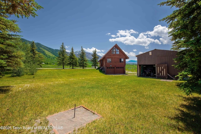 11 E St, Star Valley Ranch, WY 83127 - view of green lawn with an outdoor structure, a pole building, a mountain view, and a garage
