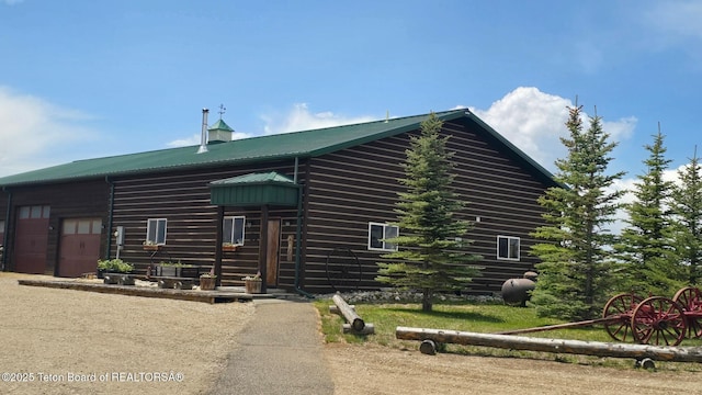 15 E Badger Trl, Pinedale, WY 82941 - log cabin with a metal roof, an attached garage, and driveway