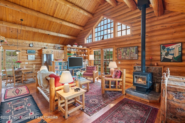 53 Schenck Ln, Dubois, WY 82513 - living area with a wood stove, log walls, french doors, a wooden ceiling with exposed beams, and hardwood / wood-style floors