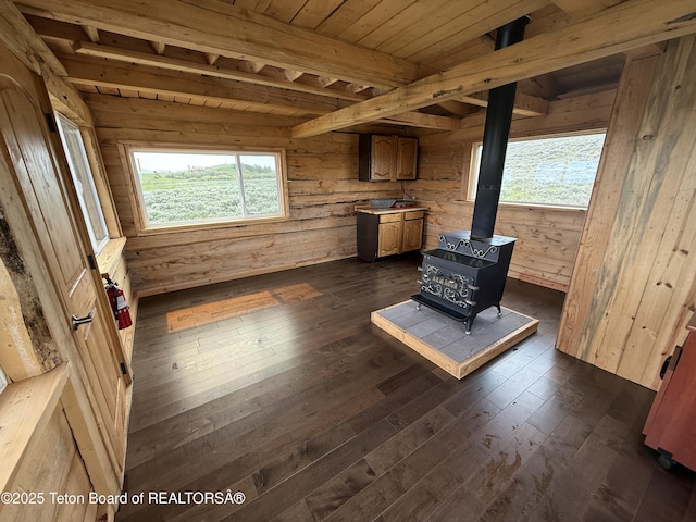 12 Beaver Ridge Cir, Daniel, WY 83115 - unfurnished living room featuring dark wood-type flooring, a wood stove, a wood ceiling with exposed beams, and wood walls