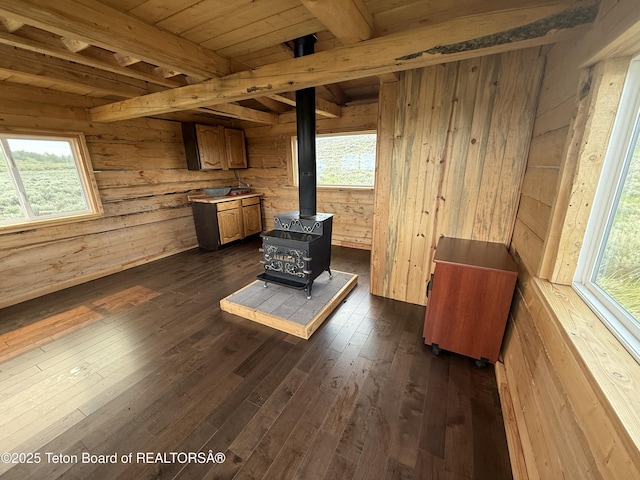 12 Beaver Ridge Cir, Daniel, WY 83115 - unfurnished living room with a wood stove, wooden walls, dark wood finished floors, and a wood ceiling with exposed beams