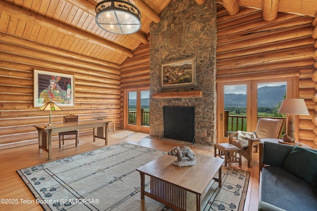 1520 N Pratt Rd, Jackson, WY 83001 - living room with a wood ceiling with exposed beams, a mountain view, log walls, healthy amount of natural light, and wood finished floors