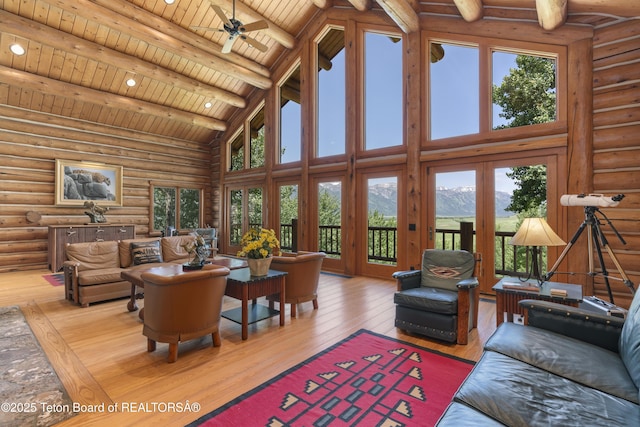 1520 N Pratt Rd, Jackson, WY 83001 - living area with a mountain view, a wood ceiling with exposed beams, high vaulted ceiling, hardwood / wood-style floors, and log walls