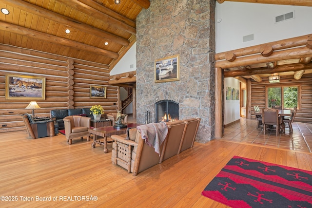 1520 N Pratt Rd, Jackson, WY 83001 - living area featuring log walls, wood-type flooring, high vaulted ceiling, a wooden ceiling with exposed beams, and a fireplace