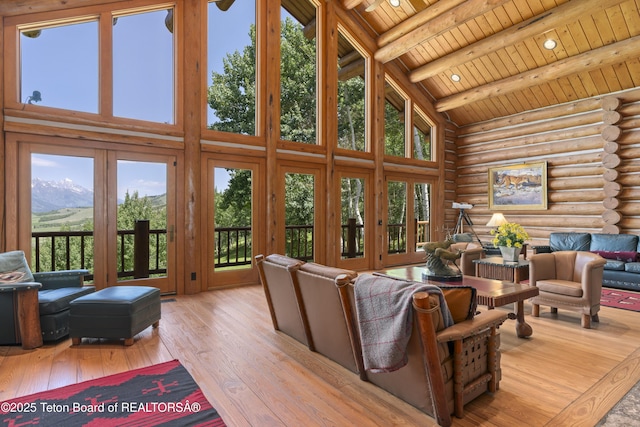 1520 N Pratt Rd, Jackson, WY 83001 - living area with rustic walls, a wood ceiling with exposed beams, high vaulted ceiling, hardwood / wood-style flooring, and a mountain view