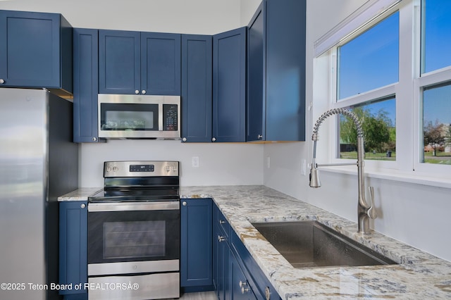 436 E Little Ave, Driggs, ID 83422 - kitchen with appliances with stainless steel finishes, blue cabinetry, and light stone counters