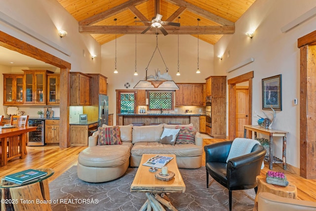 445 Aspen Ridge Trl, Alpine, WY 83128 - living room with a wood ceiling with exposed beams, beverage cooler, light wood-type flooring, high vaulted ceiling, and ceiling fan