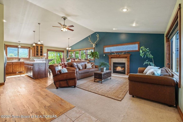 172 Brome Dr, Victor, ID 83455 - living area featuring lofted ceiling, a tile fireplace, a ceiling fan, light wood-style flooring, and recessed lighting