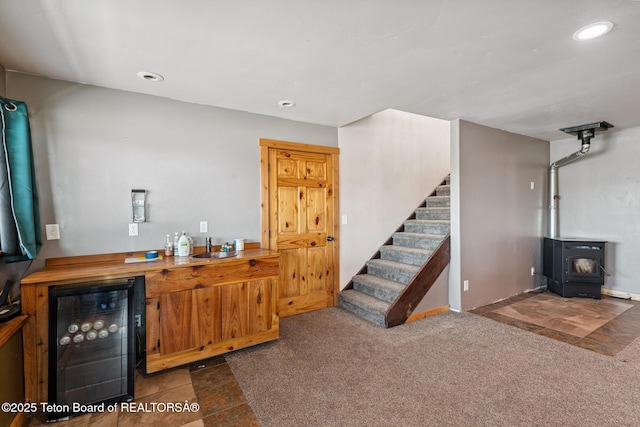 25 Neosha Trl, Boulder, WY 82923 - indoor dry bar with beverage cooler, a wood stove, stairway, recessed lighting, and carpet floors