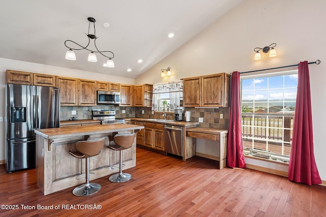 25 Neosha Trl, Boulder, WY 82923 - kitchen featuring appliances with stainless steel finishes, open shelves, brown cabinets, a kitchen island, and wood finished floors