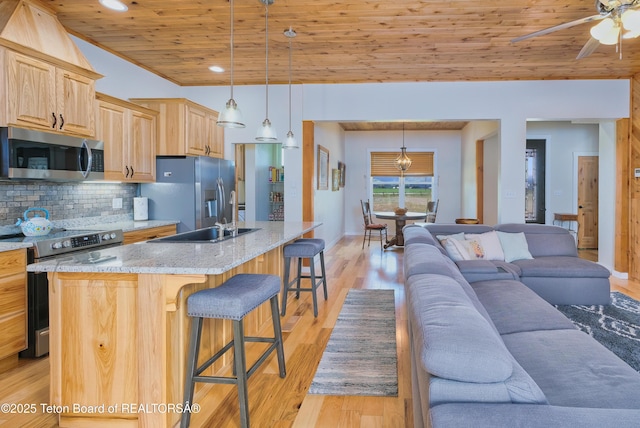 3139 Swan Valley Hwy, Swan Valley, ID 83449 - kitchen featuring appliances with stainless steel finishes, wooden ceiling, a kitchen breakfast bar, light brown cabinetry, and open floor plan