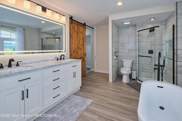 3139 Swan Valley Hwy, Swan Valley, ID 83449 - bathroom featuring a freestanding tub, double vanity, a shower stall, wood finished floors, and recessed lighting