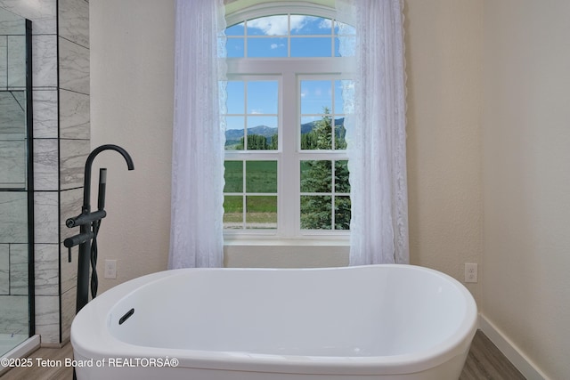 3139 Swan Valley Hwy, Swan Valley, ID 83449 - bathroom with a freestanding bath, wood finished floors, and a textured wall
