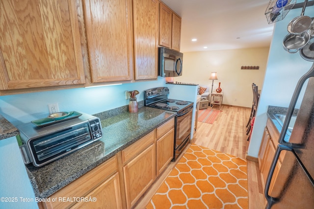 200 Homestead Rd Unit 309, Victor, ID 83455 - kitchen with black appliances, light wood finished floors, dark stone counters, and recessed lighting