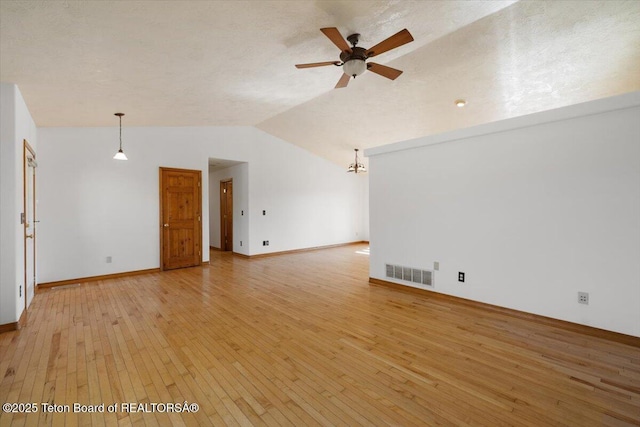 7302 Lakeside Rd, Victor, ID 83455 - unfurnished living room with light wood finished floors, ceiling fan, and vaulted ceiling