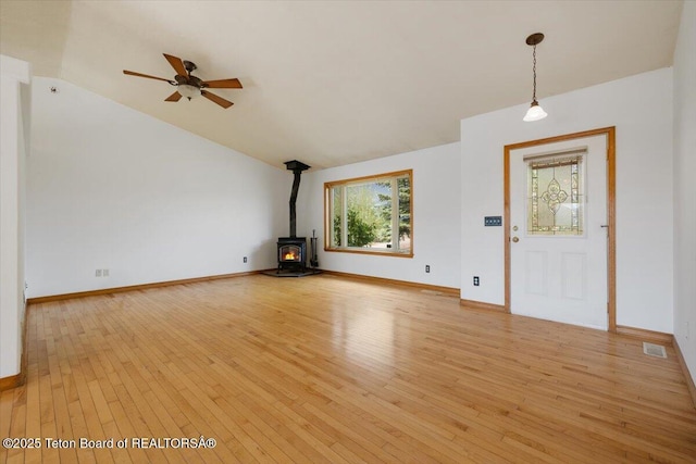 7302 Lakeside Rd, Victor, ID 83455 - unfurnished living room with light wood-style flooring, ceiling fan, a wood stove, and vaulted ceiling