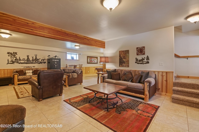 1802 Dusty Trl, Auburn, WY 83111 - living area with light tile patterned flooring, a wainscoted wall, stairs, wood walls, and beam ceiling