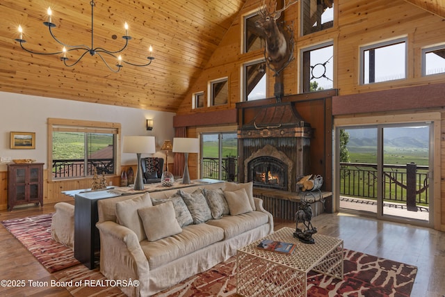 1802 Dusty Trl, Auburn, WY 83111 - living room featuring high vaulted ceiling, healthy amount of natural light, wood-type flooring, wooden ceiling, and a warm lit fireplace