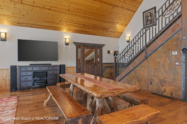 1802 Dusty Trl, Auburn, WY 83111 - dining area featuring stairway, a wainscoted wall, wood finished floors, wood walls, and wood ceiling