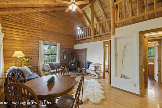 4821 S 2000 E, Victor, ID 83455 - dining room featuring a wood stove, a wood ceiling with exposed beams, high vaulted ceiling, ceiling fan, and light wood-style floors