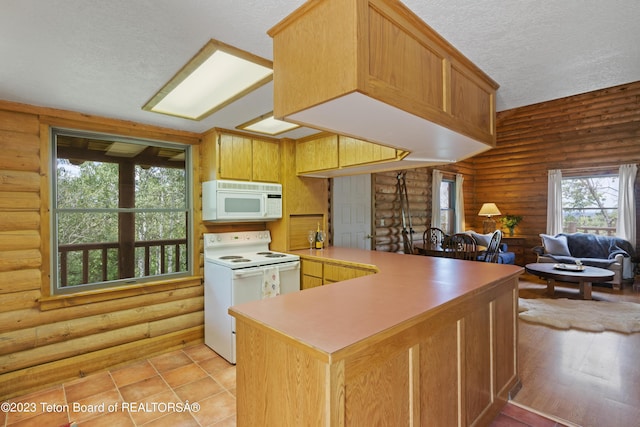4821 S 2000 E, Victor, ID 83455 - kitchen featuring white appliances, log walls, a textured ceiling, a peninsula, and open floor plan